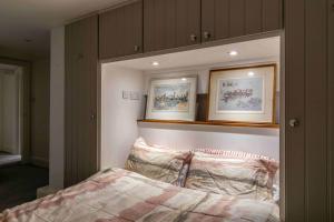 a bedroom with a bed with two pictures above it at Shared Guest House 5 mins walk from Vauxhall and Nine Elms Station with off-site parking near US embassy in London
