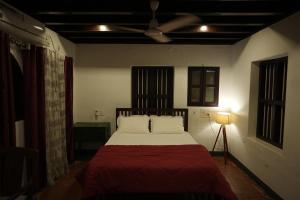 Schlafzimmer mit einem Bett und einem Deckenventilator in der Unterkunft Kayyalas Courtyard in Thrissur