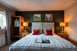 a bedroom with a large bed with red pillows at Crown Inn at Tolldown in Chipping Sodbury