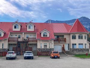 a large house with cars parked in a parking lot at Riverside Condos by Fernie Central Reservations in Fernie