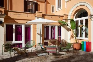 a group of chairs and an umbrella in front of a building at JO&JOE ROMA in Rome