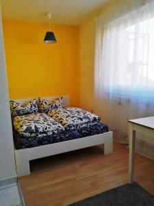 a bed in a room with a yellow wall at Big Apartments in Dortmund