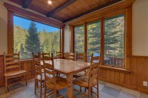 une salle à manger avec une table et des chaises et une grande fenêtre dans l'établissement Swiss Chalet-Palisades, 6 BR, Hot Tub, Pets Ok, Ski Shuttle!, à Olympic Valley