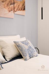 a white bed with pillows on top of it at Dolci Coccole Small Suite a Bari città! in Bari