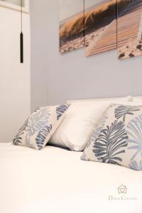 a bed with two pillows on top of it at Dolci Coccole Small Suite a Bari città! in Bari