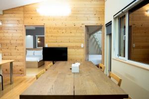 湯の里699 في Kombu: طاولة خشبية كبيرة في غرفة مع غرفة نوم