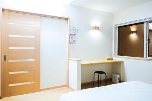 a bedroom with a bed and a desk and a window at 湯の里699 in Kombu