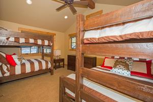 une chambre avec deux lits superposés et un ventilateur de plafond dans l'établissement Truckee Treasure at Grays Crossing by Tahoe Getaways - Relaxing Home w Private Hot Tub, Dogs Welcome!, à Truckee