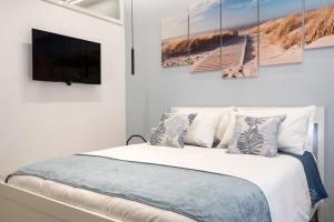 a bedroom with a bed with a tv on the wall at Dolci Coccole Small Suite a Bari città! in Bari +35 photos