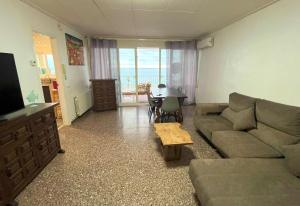 ピネダ・デ・マールにあるApartamento frente del marのソファとテーブルのあるリビングルーム