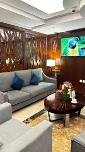 Laten Suites Prince Sultan في جدة: غرفة معيشة مع أريكة وطاولة