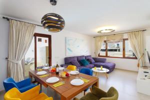 a living room with a table and a purple couch at Villa Tisalaya by Villa Plus in Puerto del Carmen