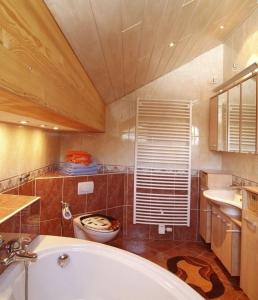 uma casa de banho com uma banheira, um WC e um lavatório. em Landhaus am Rennweg em Neuhaus am Rennweg