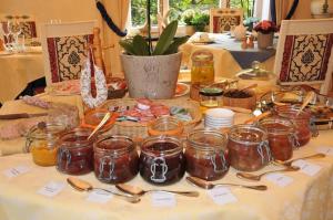 un tavolo con barattoli di miele e cucchiai sopra di Hotel La Ferronniere a Bouillon