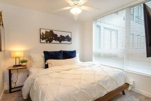 a bedroom with a white bed and a window at Balcony,gym,rooftop Grill,terrace, Kingbed, 4k Tv in Tacoma