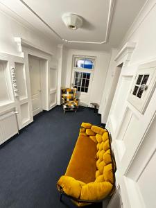 a living room with a yellow couch and chairs at Hotel Krasnoludki in Sosnówka