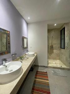 Un baño con dos lavabos y una ducha. en Casa las Alas de San Miguel, en San Miguel de Allende