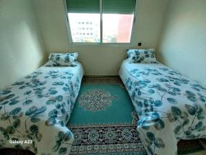 two beds in a small room with a window at Large Appartement Rabat Salé - SwiftStay - Sidi Abdellah in Salé