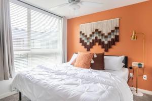 a bedroom with a white bed with an orange wall at Blackout Curtainsking Bedin-suite Wdbalcony in Tacoma
