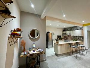 a kitchen with two bar stools and a refrigerator at Casa las Alas de San Miguel in San Miguel de Allende