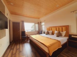 ein Schlafzimmer mit großem Bett und Fenster in der Unterkunft Maywood Hotel in Shimla