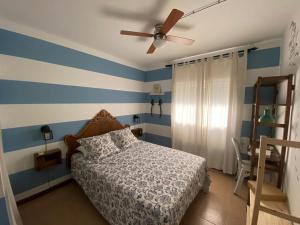 a bedroom with blue and white striped walls and a bed at Lola's Beach House in Calafell +25 photos