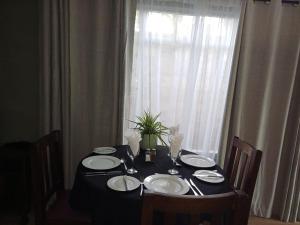 a black table with plates and a plant on a window at The Viewing Deck Accommodation in Clarens