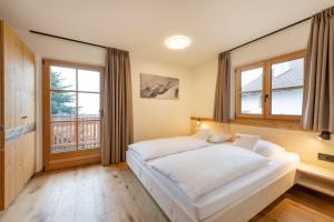 Un dormitorio con una cama blanca y una ventana grande. en Apartments Schmalzerhof - Eppan an der Weinstraße, en Appiano sulla Strada del Vino 76 fotos más