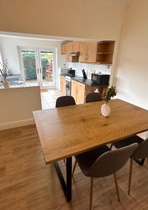 - une cuisine avec une table en bois et des chaises dans l'établissement Millfield House by Blue Skies Stays, à Middlesbrough