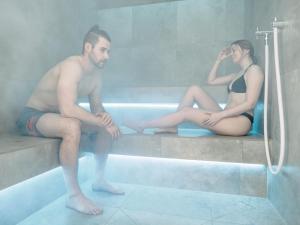 Un uomo e una donna seduti in una vasca da bagno di MYALPS Ötztal a Umhausen