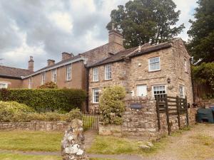 an old stone house with a gate in front of it at A D Coach House Cottage in Richmond