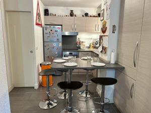 cocina con encimera con taburetes y nevera en Appartement Les Gets, 2 pièces, 6 personnes - FR-1-623-82, en Les Gets