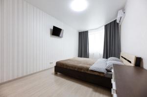 1 dormitorio con 1 cama y TV en la pared en 0272 Нова затишна квартира ЖК Щасливий, en Kiev