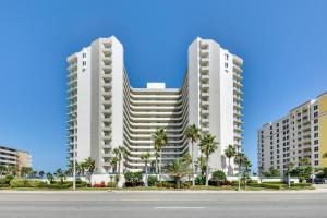 two tall buildings with palm trees in front of a street at Eclectic Daytona Beach Condo with Breathtaking View! in Daytona Beach