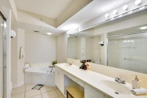 a bathroom with two sinks and a large mirror at Eclectic Daytona Beach Condo with Breathtaking View! in Daytona Beach +23 photos