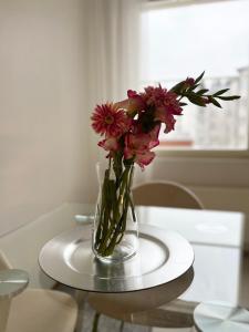 un jarrón de flores rosas sentado en una mesa en Star of Annala, en Tampere