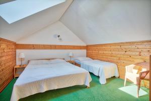 two beds in a room with wooden walls at Apartmány nad stájemi - Jítravský Dvorec in Rynoltice