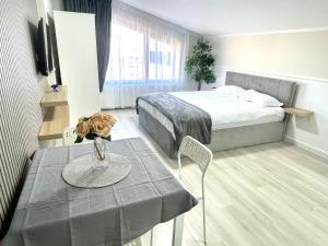 a hotel room with a bed and a table with a table at Baneasa Luxury Apartaments in Bucharest