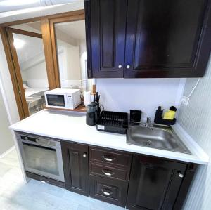 a kitchen with a sink and a microwave at Baneasa Luxury Apartaments in Bucharest