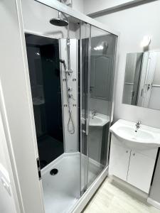 La salle de bains est pourvue d'une douche et d'un lavabo. dans l'établissement Baneasa Luxury Apartaments, à Bucarest