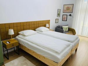 a bedroom with a large bed and a chair at Margaret Boulevard Apartment - with balcony in Budapest