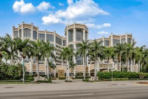 a large building with palm trees in front of a street at Marco Beach Ocean Resort 907 in Marco Island