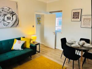 a living room with a green couch and a table at Stylish Central Apartment in Cardiff