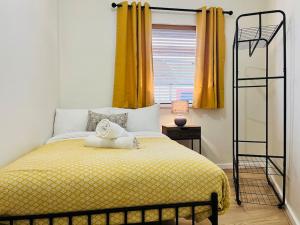 a bedroom with a bed with a yellow blanket at Stylish Central Apartment in Cardiff