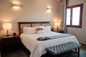 1 dormitorio con 1 cama blanca grande y 2 lámparas en Casa Lucila Hotel Boutique, en Mazatlán