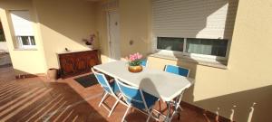 a kitchen with a white table and blue chairs at RINCÓN DEL MIÑO in Tomiño