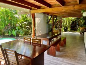 a dining room with a wooden table and chairs at Santeria Lodge in Santa Teresa Beach