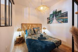 een slaapkamer met een bed met een blauw dekbed bij Bali Dream II Hyper Centre Fontaine Moussue in Salon-de-Provence