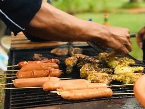 a person grilling meat and vegetables on a grill at Villa Florence in Nuwara Eliya