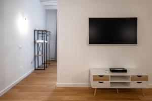 a living room with a tv on a white wall at Taggami b&b in Nocera Inferiore
